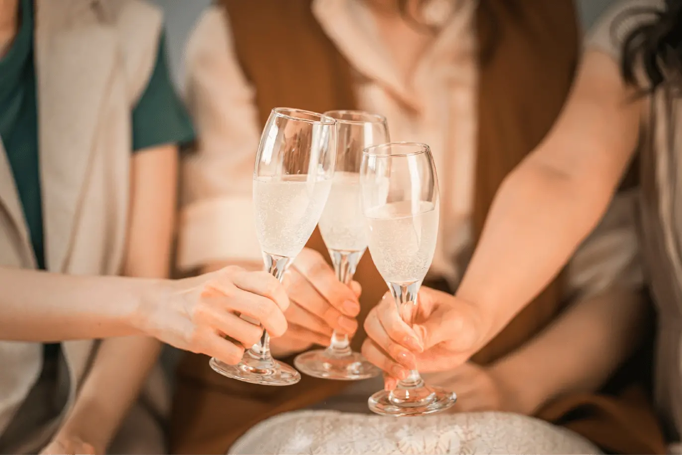 シャンパングラスで乾杯している画像